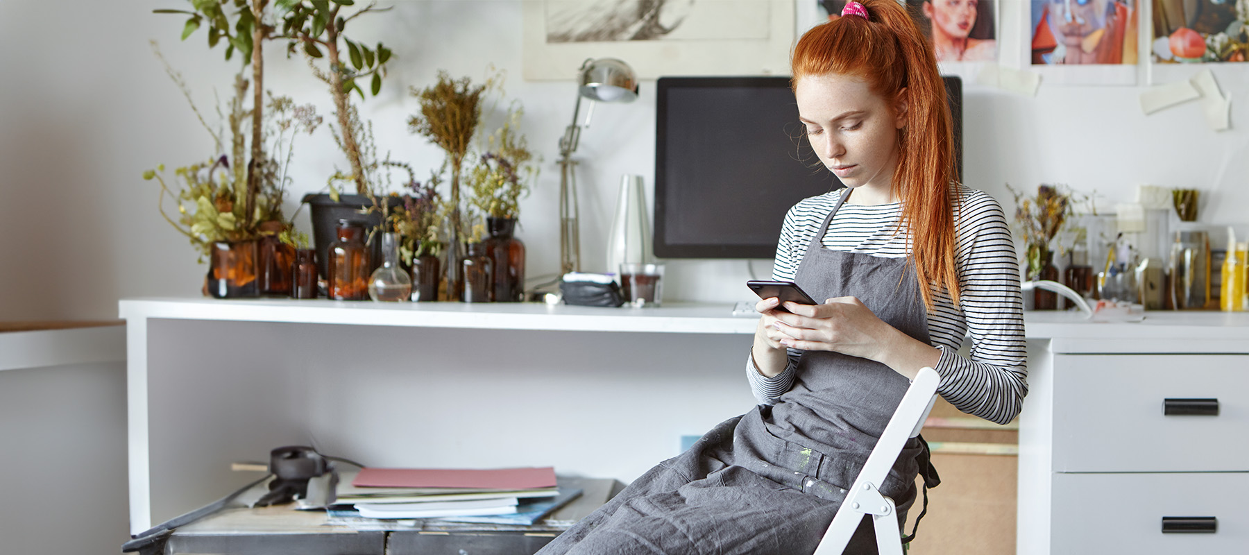 mujer pelirroja miran en su móvil herramientas para redes sociales