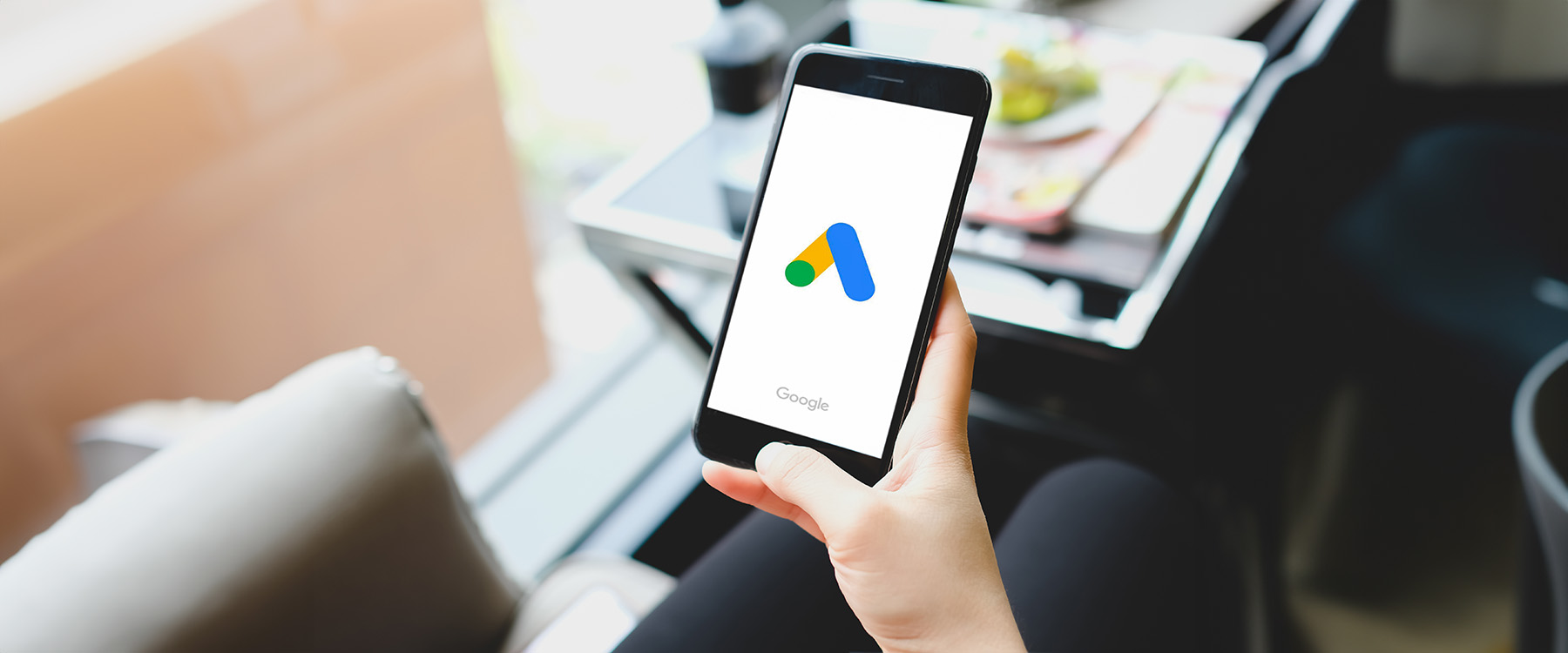 Teléfono móvil con logo de Google Ads para ver sus campañas de máximo rendimiento