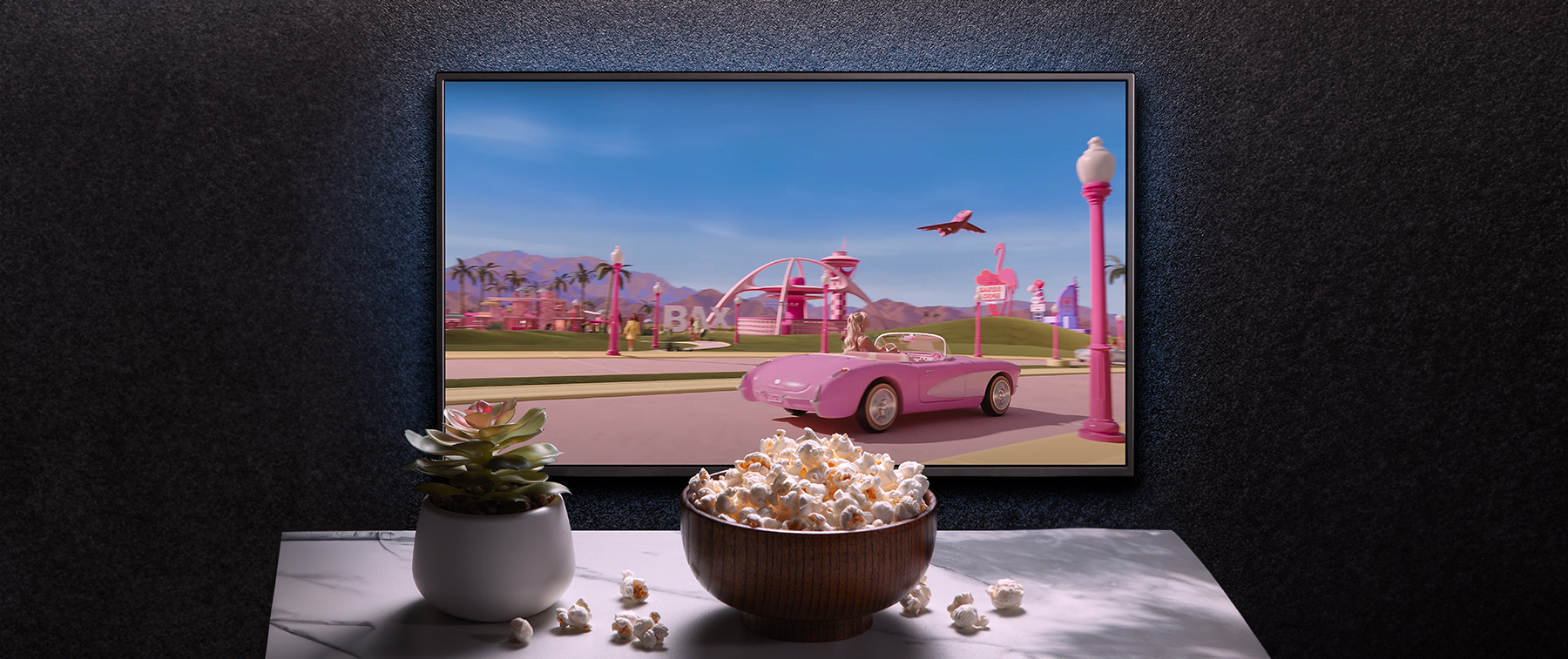 Mesa con palomitas y película de barbie en la televisión
