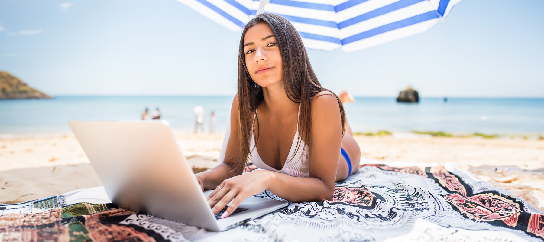 Mujer trabajando su estrategia de marketing de contenidos en verano en la playa