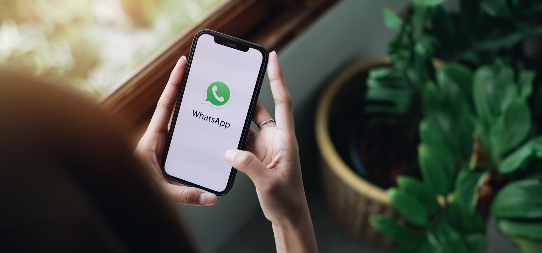 mujer mirando móvil con las nuevas funciones de whatsapp 2023