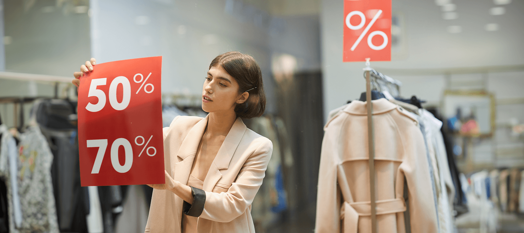 Mujer pegando carteles con estrategias de pricing Black Friday en su tienda